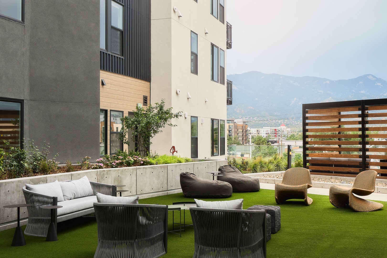 Chairs on grass surrounded by apartment windows